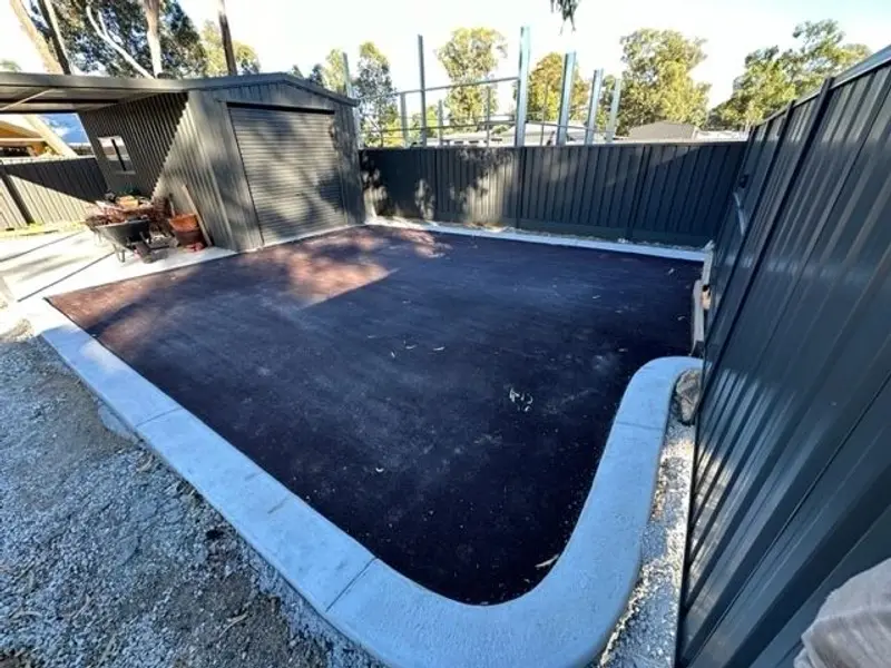 Asphalt pad with new concrete kerb