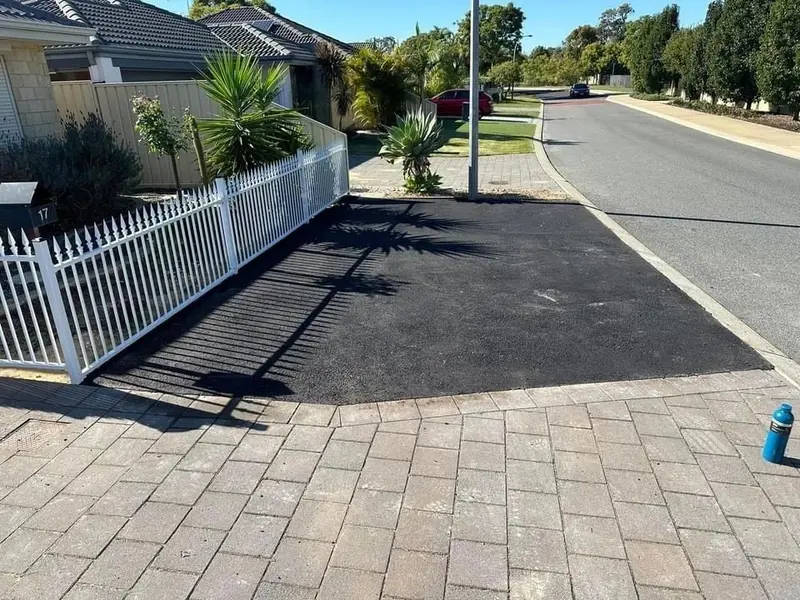 Asphalt driveway meeting brick paving