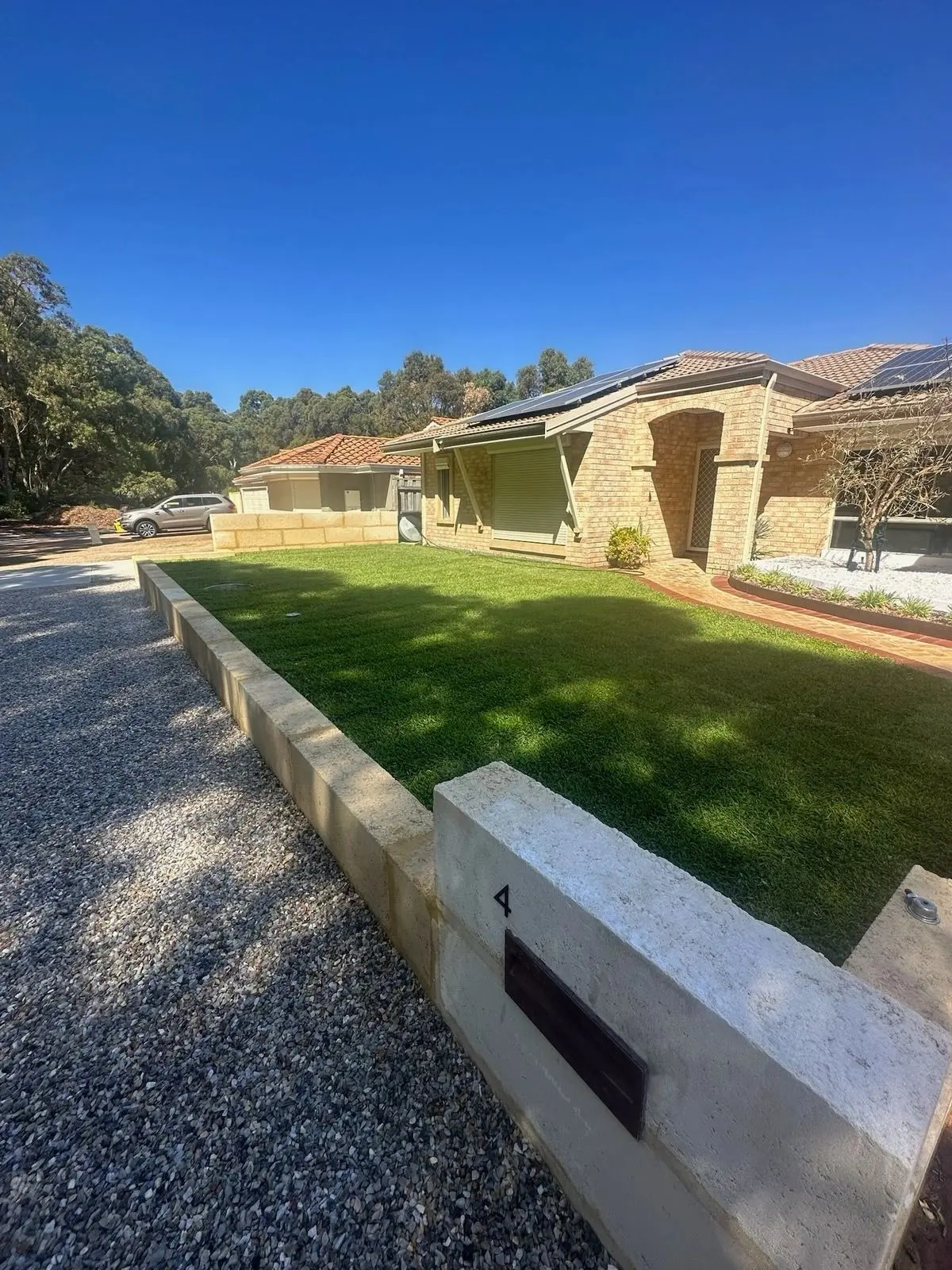 Finished front yard with limestone wall, new lawn and gravel