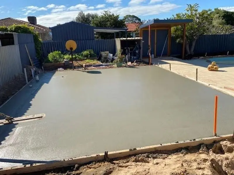 Freshly poured concrete slab in a backyard